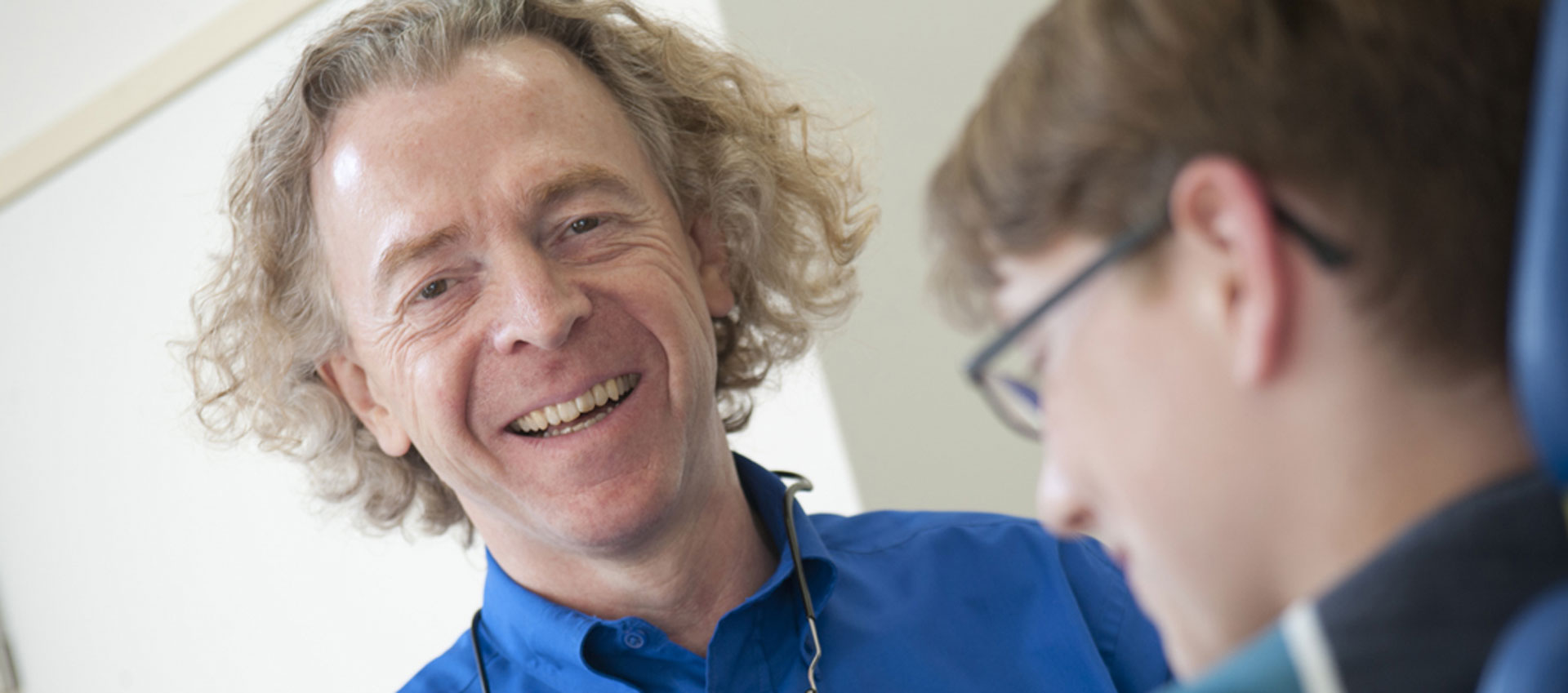 Ausbild über Bäume hinweg auf einen See mit Bergen im Hintergrund